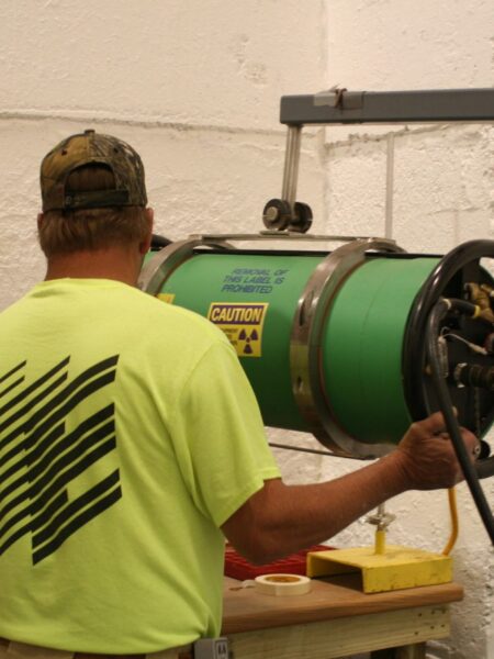 An Encorus employee prepares radiography equipment